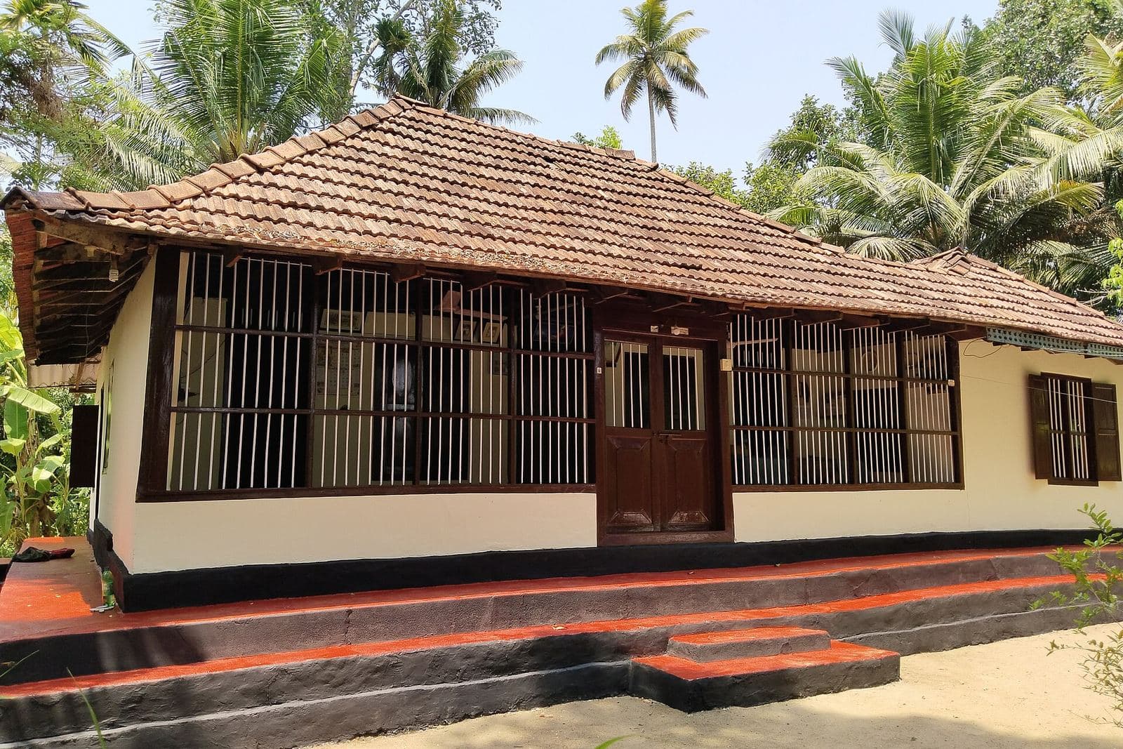 Tiled-roof farmhouse among coconut palms